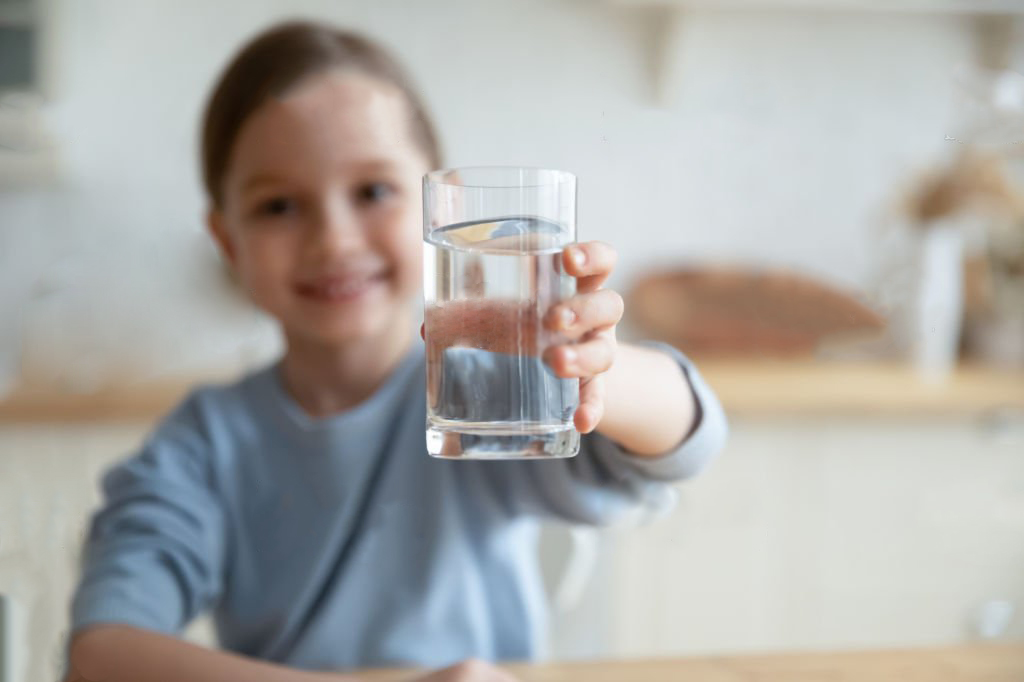 A child with a glass of water for hydrating and moisturizing skin