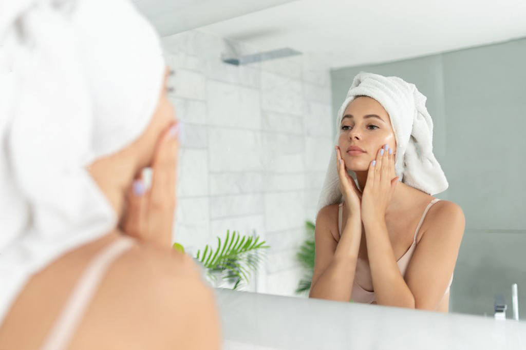 A woman with moisturized face in front of the mirror 